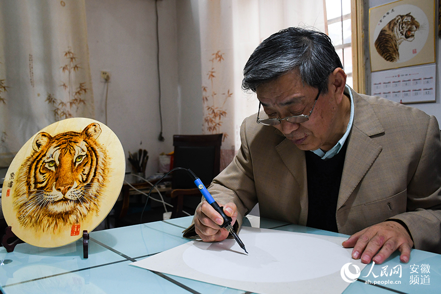 非遗传承人吴善明在宣纸上准备作画。人民网 周坤摄