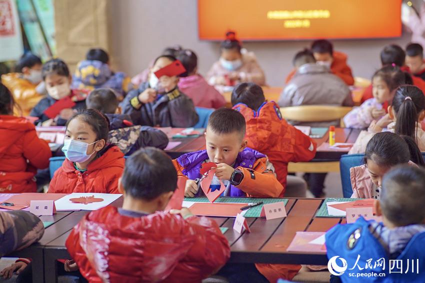 孩子们动手剪“老虎”“新春”等富有吉祥寓意的剪纸作品。翁光建摄