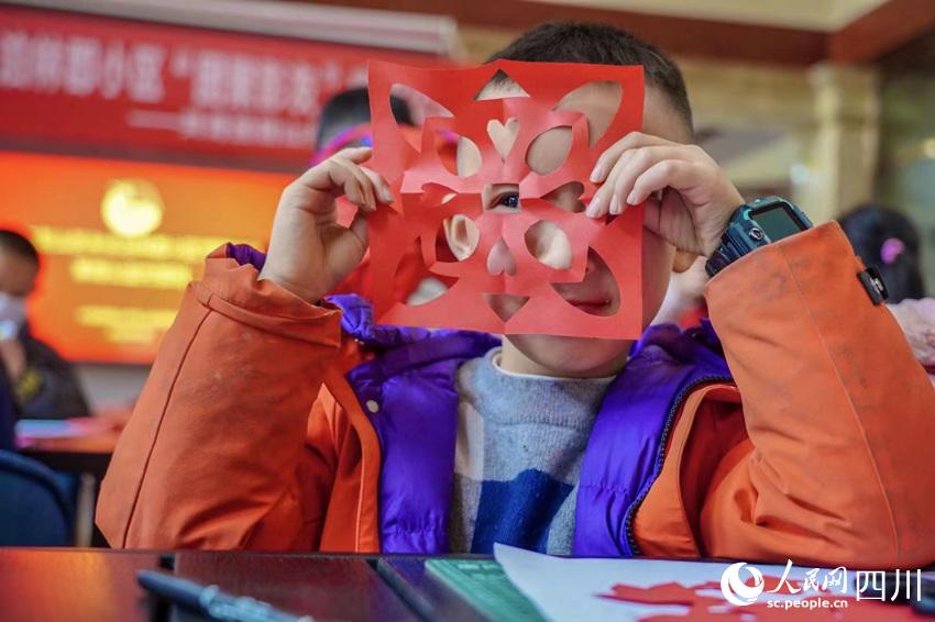 孩子高兴的展示自己的剪纸作品。翁光建摄