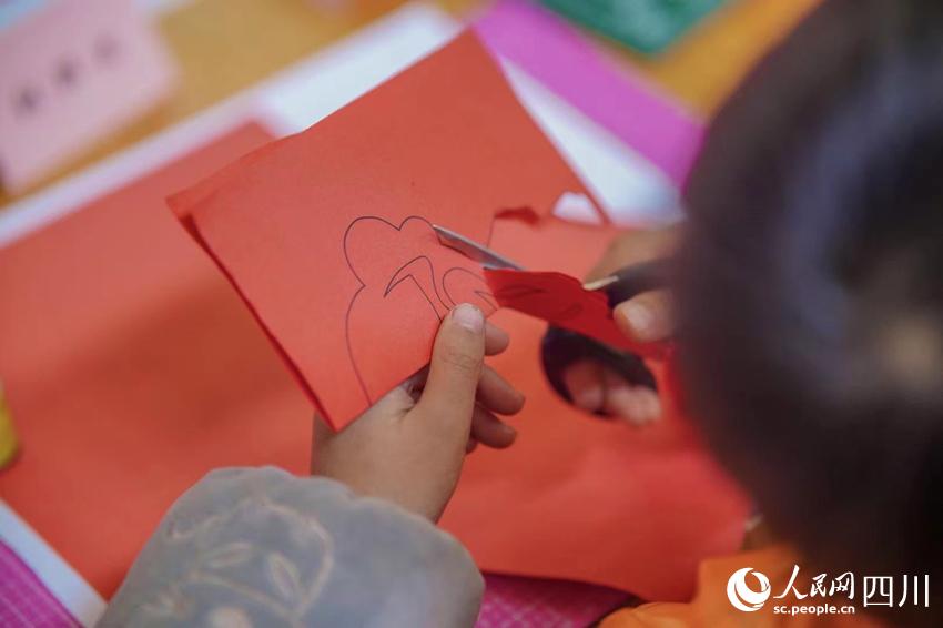 孩子认真制作剪纸作品。翁光建摄