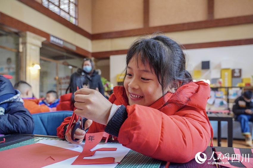 孩子认真制作剪纸作品。翁光建摄