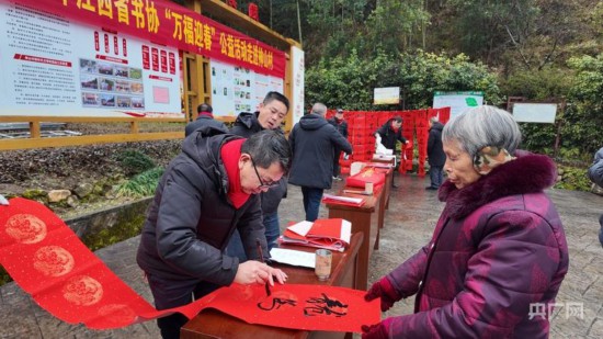 井冈山市书法家协会的同志正在为村民写春联（央广网记者 郇康新 摄）